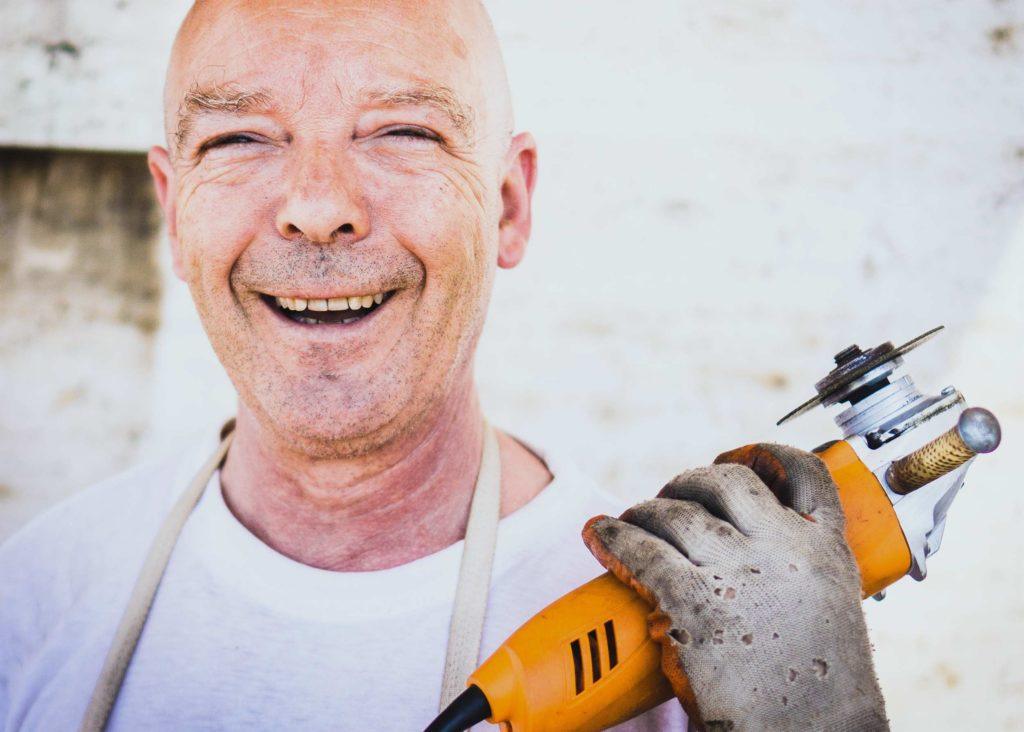 A smiling worker holding a power tool