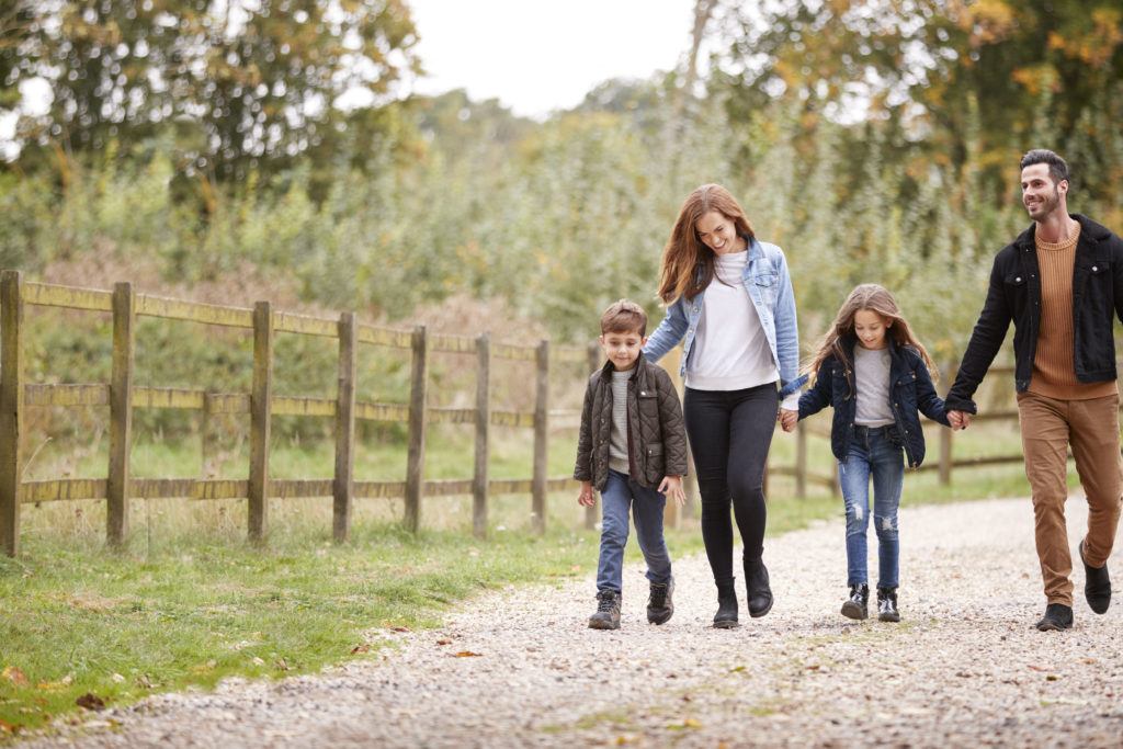 Family On Autumn Walk In Countryside Together