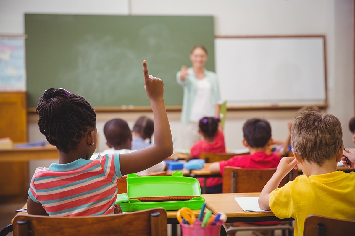 Pupils raising their hands during class at the elementary school