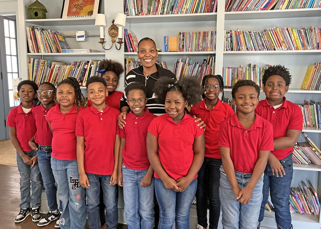 Students in matching red shirts standing together in a school library