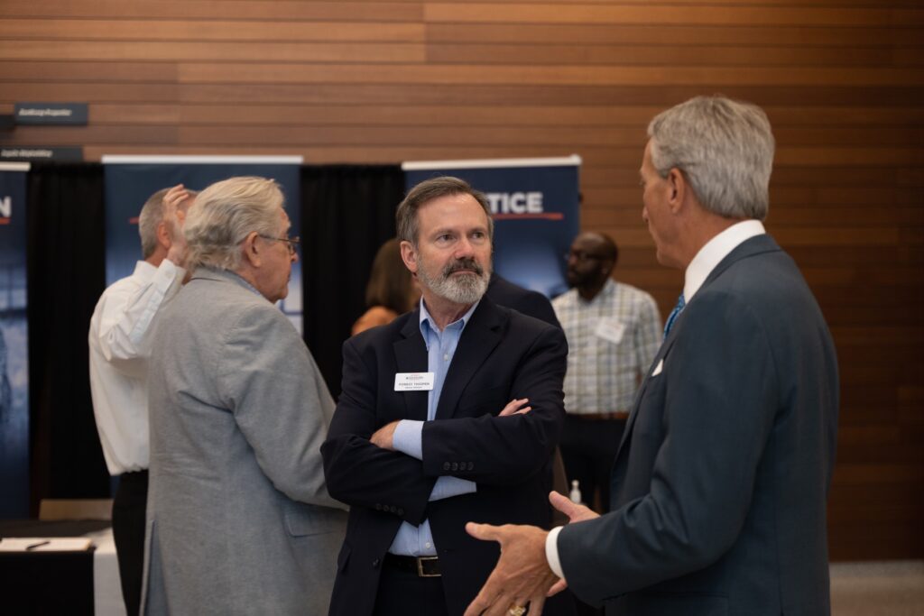 Three men in conversation at an Empower Mississippi event