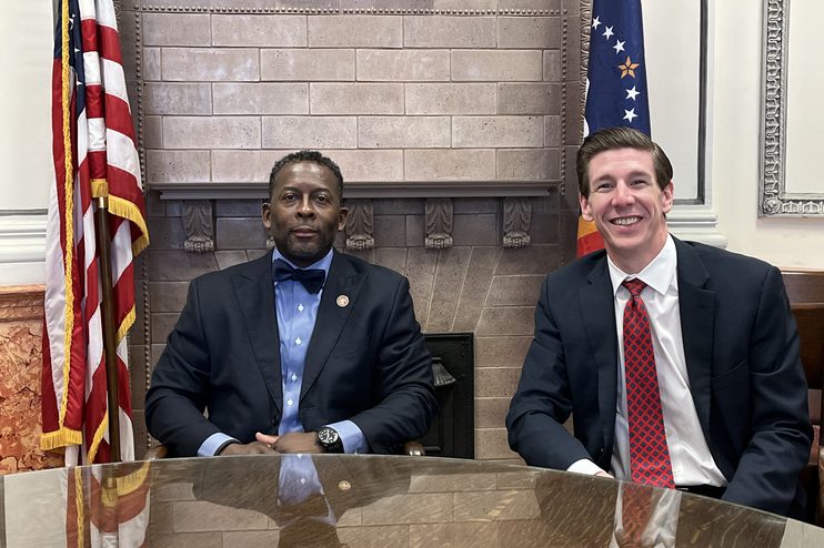 Two men seated for a Capitol Chat recording, with United States and Mississippi flags behind them
