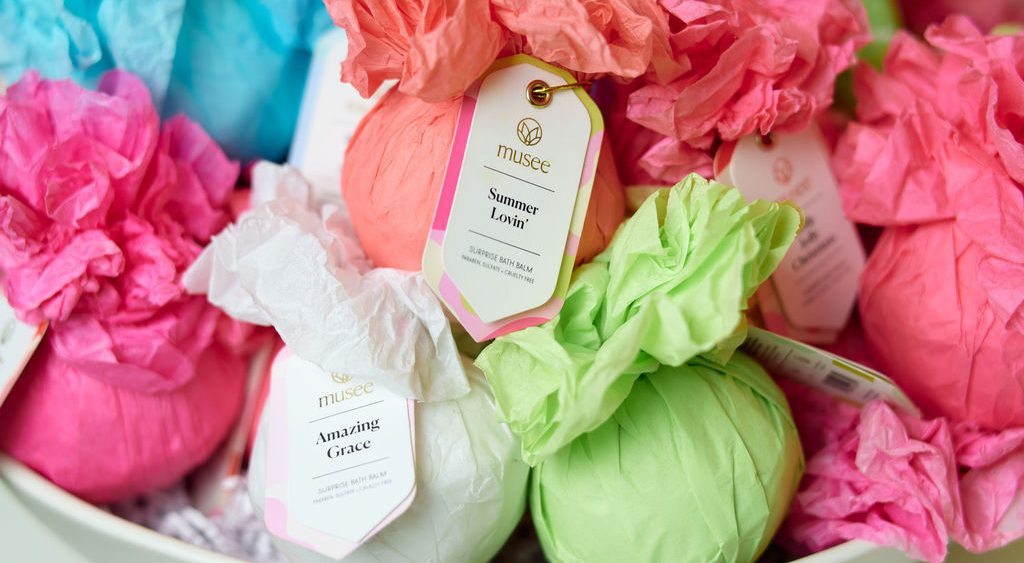 Wrapped gift items in tissue paper arranged in a bowl