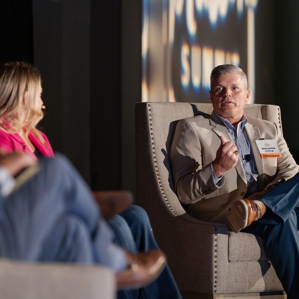 A man speaking from an armchair on stage during a panel discussion